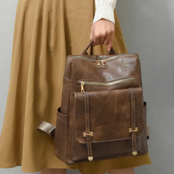Femme portant le sac a dos cuir femme comme sac à main à la main.