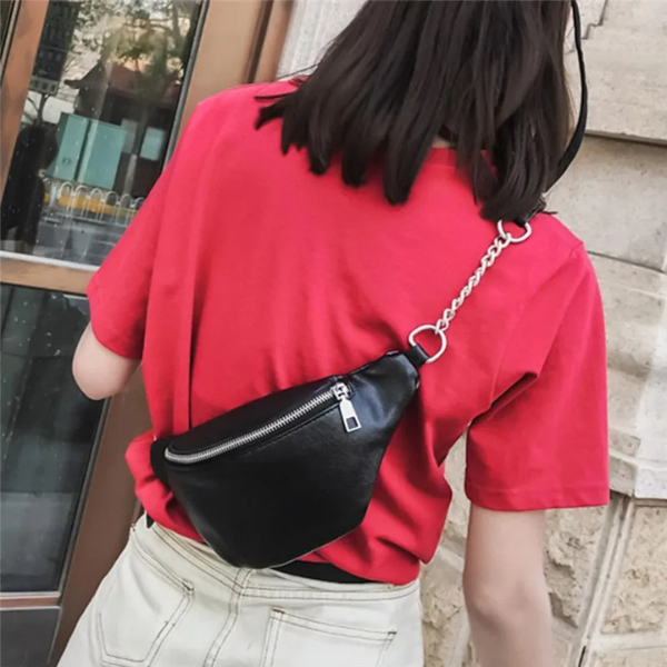 Femme en t-shirt rouge portant un sac banane en cuir noir avec chaîne