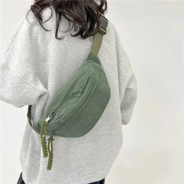 femme portant un grand sac banane vert en velours côtelé dans le dos