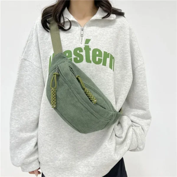 rand sac banane vert pour femme porté en bandoulière sur un sweat gris