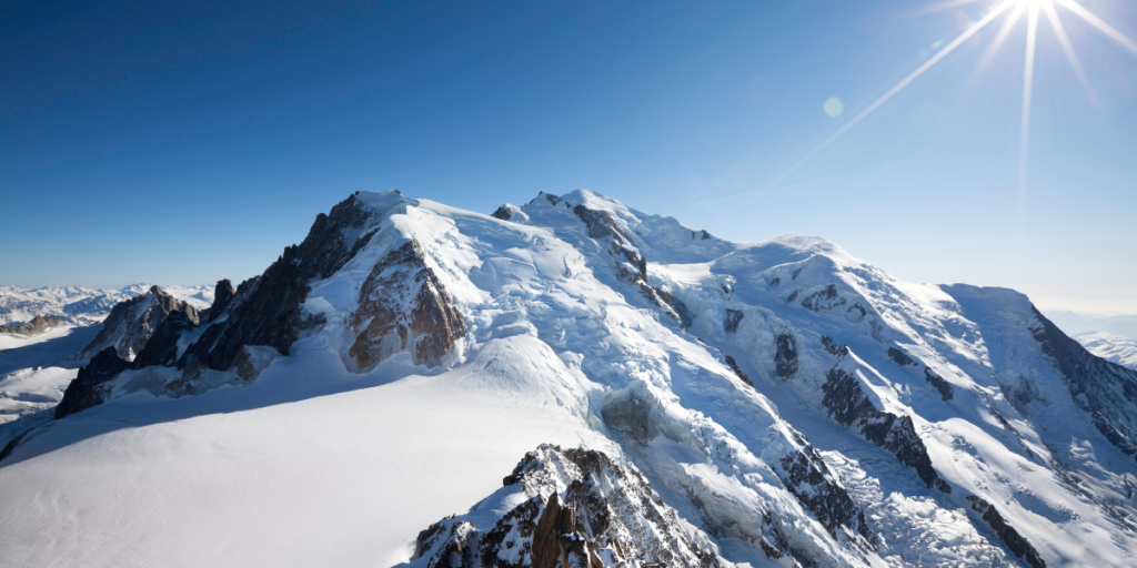 Vue panoramique sur le Mont Blanc recouvert de neige sous un ciel bleu éclatant.