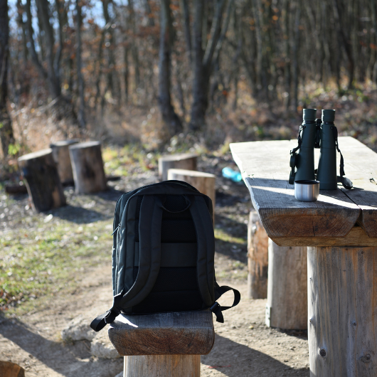 Sac à dos ergonomique posé sur un banc en forêt pendant une randonnée
